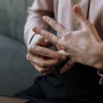 Close-up of a person removing a wedding ring, symbolizing relationship change or decision.