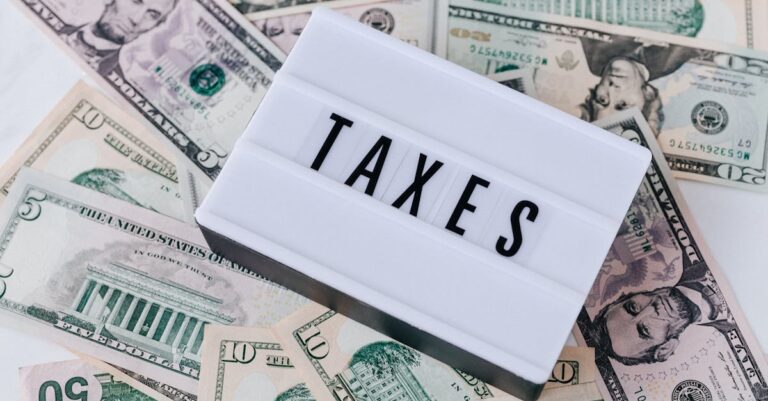 US dollar bills surrounding a sign showing 'TAXES'. Ideal for financial context.