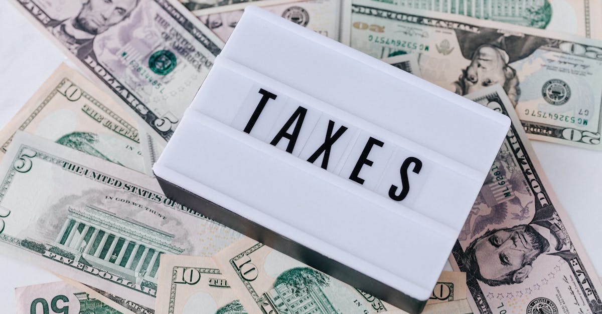 US dollar bills surrounding a sign showing 'TAXES'. Ideal for financial context.