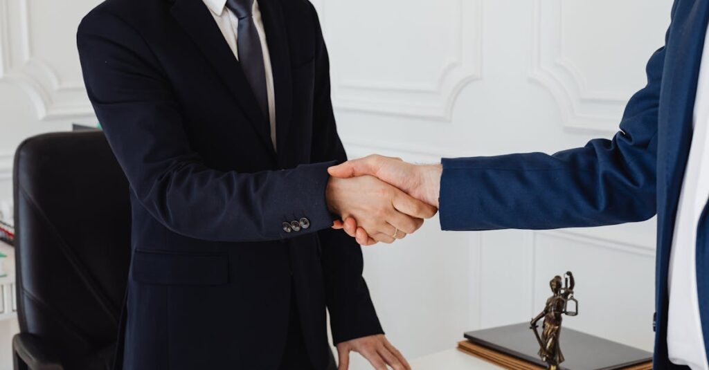 Two men in suits shaking hands in a formal office environment symbolizing an agreement.